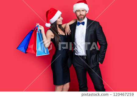 merry christmas to smiling couple with shopping bags in studio. shopping couple at christmas sale. 120467259
