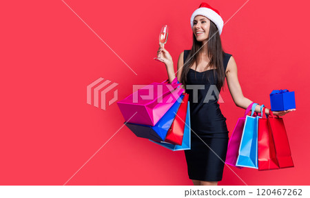 shopper woman in santa hat, copy space. santa woman shopper on sale isolated on red shopper woman in santa hat, copy space. santa woman shopper on sale isolated on red 120467262