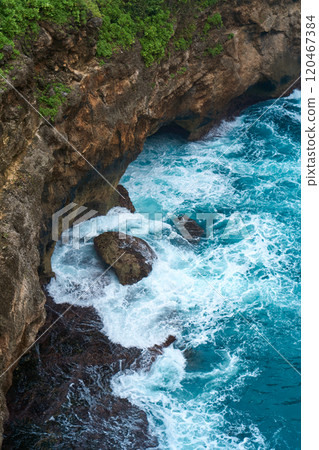 Cinematic aerial landscape shots of the beautiful island of Nusa Penida. Huge cliffs by the shoreline and hidden dream beaches with clear water and foaming wave. 120467384