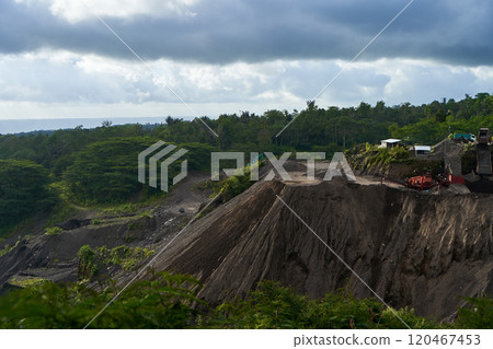 A stone quarry in Indonesia. Large equipment such as bulldozers and dump trucks are working on the site. 120467453