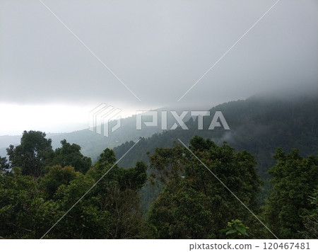 Lush green tropical mountains with a rain cloud at the peak. 120467481