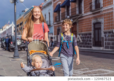 Mother tourist with her toddler and teenage sons walking through the colorful colonial streets of Puebla, Mexico. Travel, cultural exploration, and vibrant architecture concept Mother tourist with her toddler and teenage sons walking through the colorful colonial streets of Puebla, Mexico. Travel, cultural exploration, and vibrant architecture concept 120467523