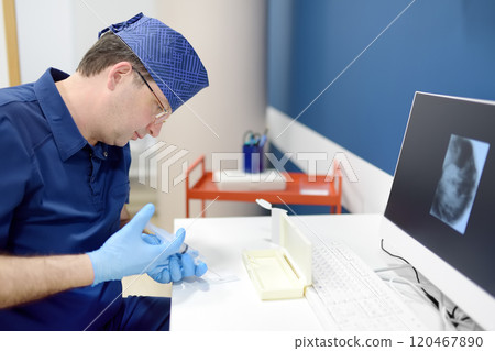 Oncologist performing a cancer biopsy test during the appointment of patient. The doctor applies a sample from a syringe to a slide. Oncologist performing a cancer biopsy test during the appointment of patient. The doctor applies a sample from a syringe to a slide. 120467890