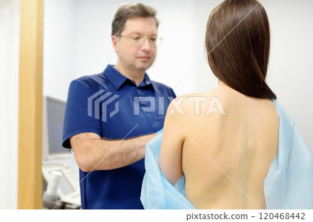 Doctor mammologist examines woman breasts. Correcting the shape of the breast - lift, reduction, reconstruction, augmentation. Problems of lactation. Breast cancer. 120468442