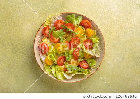Fresh salad with lettuce, cherry red and yellow tomatoes, and arugula in a bowl top view, dieting and healthy eating Fresh salad with lettuce, cherry red and yellow tomatoes, and arugula in a bowl top view, dieting and healthy eating 120468636