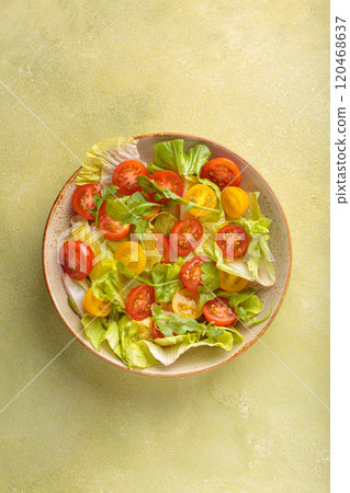 Fresh salad with lettuce, cherry red and yellow tomatoes, and arugula in a bowl top view, dieting and healthy eating Fresh salad with lettuce, cherry red and yellow tomatoes, and arugula in a bowl top view, dieting and healthy eating 120468637