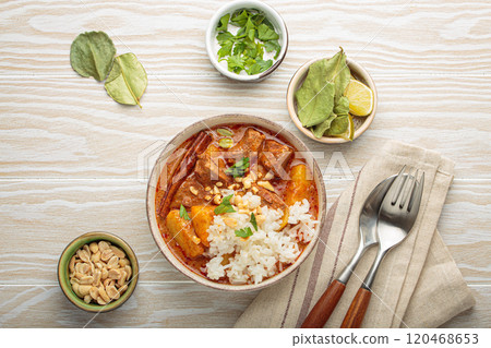 Delicious massaman curry with beef, potatoes, rice, and peanuts on white wooden background, traditional thai cuisine Delicious massaman curry with beef, potatoes, rice, and peanuts on white wooden background, traditional thai cuisine 120468653