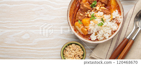 Delicious massaman curry with beef, potatoes, rice, and peanuts on white wooden background, traditional thai cuisine, space for text 120468670