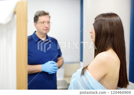 Doctor mammologist examines woman breasts. Correcting the shape of the breast - lift, reduction, reconstruction, augmentation. Problems of lactation. Breast cancer. 120468909