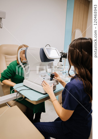 Optometrist conducting an eye test with advanced equipment in a modern clinic setting Optometrist conducting an eye test with advanced equipment in a modern clinic setting 120468943