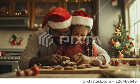 Father and daughter are smiling while decorating Christmas cookies together in their kitchen 120469649