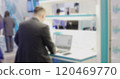 Businessman working on laptop at trade show with defocused background 120469770