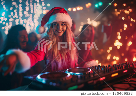 Beautiful female dj wearing a santa claus costume is mixing music at a party with festive lights in the background 120469822
