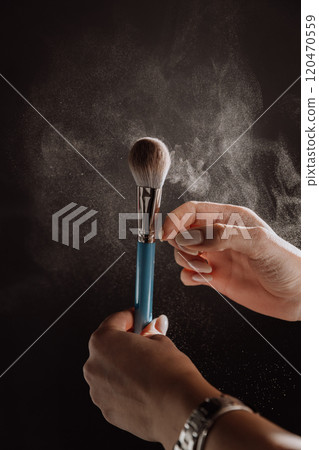 Makeup brush in action with powder particles floating in dramatic lighting, beauty in motion Makeup brush in action with powder particles floating in dramatic lighting, beauty in motion 120470559
