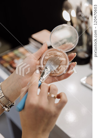 Applying bronzer with a makeup brush for a flawless and radiant complexion 120470603