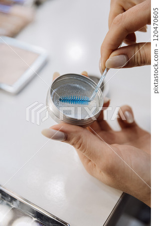 Using a blue spoolie with brow gel for precise eyebrow styling and grooming Using a blue spoolie with brow gel for precise eyebrow styling and grooming 120470605