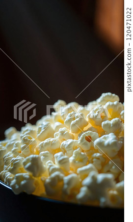 Warm, fluffy popcorn in a bowl prepared for a movie night at home 120471022