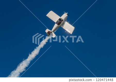 Stunt aerobatic plane performing stunts in air Stunt aerobatic plane performing stunts in air 120471448