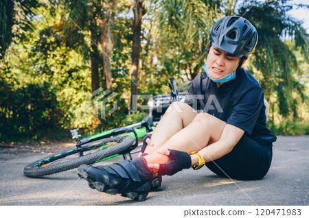 Cyclist woman having ankle pain after impact the floor by accident car crash on the road. 120471983