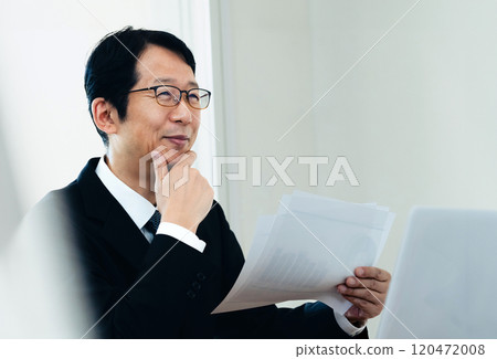Businessman looking at materials 120472008