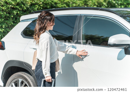 帶著手提箱的女商人用智慧鑰匙鎖車門 120472461