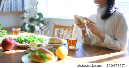 A woman takes a picture of the amount with her smartphone 120472571