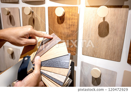 Designer hand pointing at sample of wood laminated Designer hand pointing at sample of wood laminated 120472929