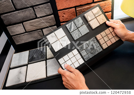 Architect hand holding stone tile collection display on sample board 120472938