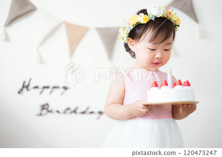 2 year old child holding a toy birthday cake 120473247