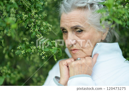 Portrait of senior sad woman in park 120473275