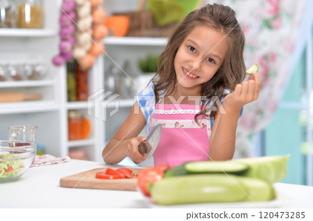 Cute happy girl coocking salad on kitchen 120473285