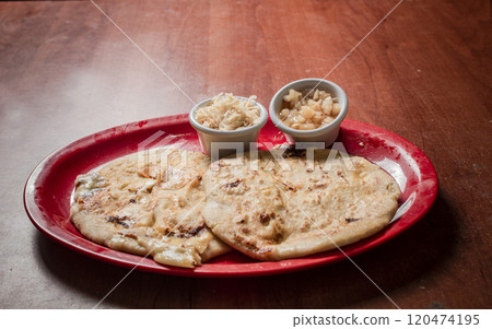 Traditional pupusas served on a wooden table, Closeup of Nicaraguan pupusas served on wooden table. Delicious traditional Salvadoran Pupusas with melted cheese on wooden table Traditional pupusas served on a wooden table, Closeup of Nicaraguan pupusas served on wooden table. Delicious traditional Salvadoran Pupusas with melted cheese on wooden table 120474195