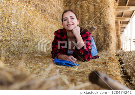 Female farmer posing on hayloft at cow farm Female farmer posing on hayloft at cow farm 120474241