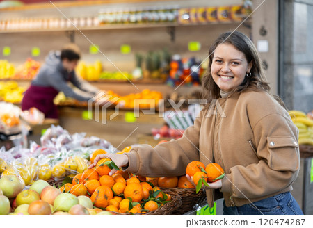 Young girl buying tangerines in grocery store 120474287