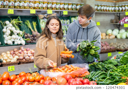 Young couple buying carrots and spinach in grocery store Young couple buying carrots and spinach in grocery store 120474301