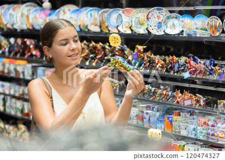 Female traveler buyer chooses ceramic ox, glass figurine of bull 120474327