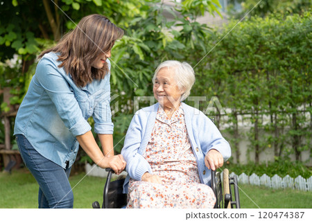 Caregiver help and care Asian senior woman patient sitting on wheelchair at nursing hospital ward, healthy strong medical. Caregiver help and care Asian senior woman patient sitting on wheelchair at nursing hospital ward, healthy strong medical. 120474387