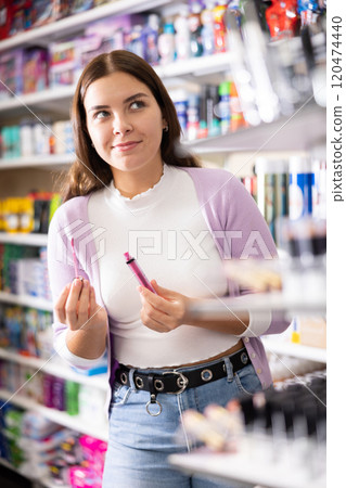 Stylish woman testing new lipstick, shopping in cosmetics store Stylish woman testing new lipstick, shopping in cosmetics store 120474440