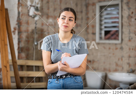 Woman making notes on indoor construction site Woman making notes on indoor construction site 120474584
