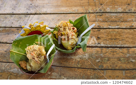 Vigoron with leaves served on a wooden table, two vigorones served on wooden background, vigoron typical food from nicaragua 120474602