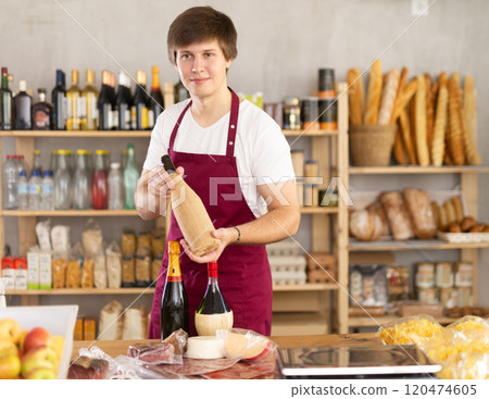 Guy employee sells alcohol drink wine, and offers wide range of snack, nutrition. Guy employee sells alcohol drink wine, and offers wide range of snack, nutrition. 120474605