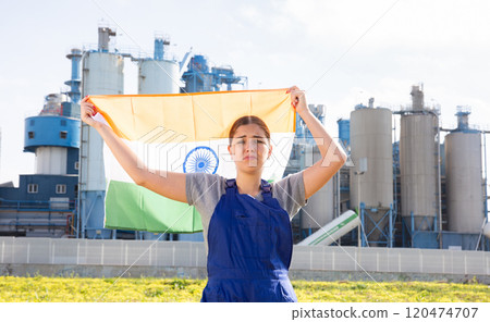Sad young woman worker with flag of India against background of factory 120474707
