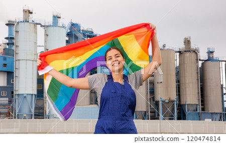 Smiling young woman near factory with LGBT flag Smiling young woman near factory with LGBT flag 120474814