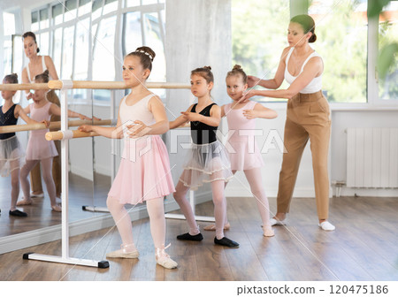 Ballet choreographer teaches little children to get into first position Ballet choreographer teaches little children to get into first position 120475186