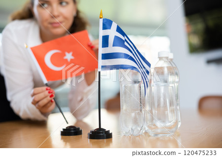 Young female secretary preparing room for international negotiations between greece and turkey Young female secretary preparing room for international negotiations between greece and turkey 120475233