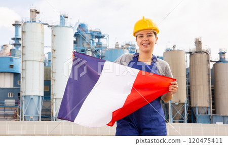 Happy woman waving flag of France against the background of modern factory Happy woman waving flag of France against the background of modern factory 120475411