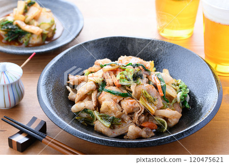 Pork kimchi served on a black plate (wood grain background) 120475621