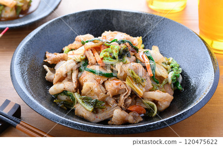 Pork kimchi served on a black plate (wood grain background) 120475622