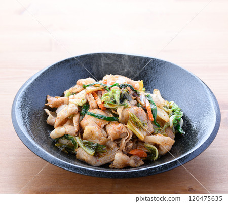 Pork kimchi served on a black plate (wood grain background) 120475635