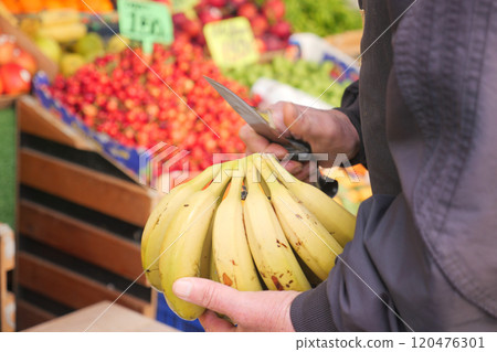 Enjoy Fresh Bananas Available at Your Local Market Surrounded by a Colorful Produce Background Enjoy Fresh Bananas Available at Your Local Market Surrounded by a Colorful Produce Background 120476301